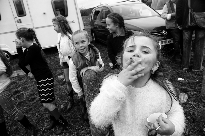 black and white photo of little girls, one of them is smoking a cigarette