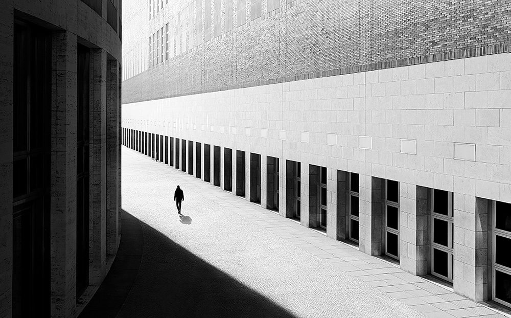 black and whit ephoto of a man walking alone on an empty street