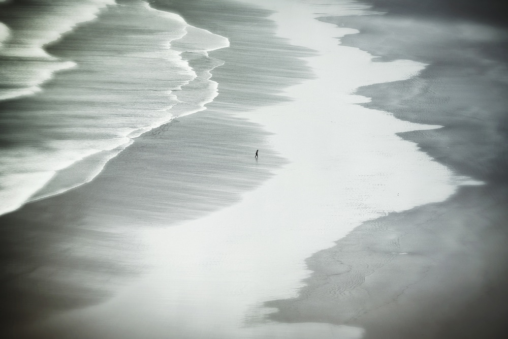 a person walking on the empty beach