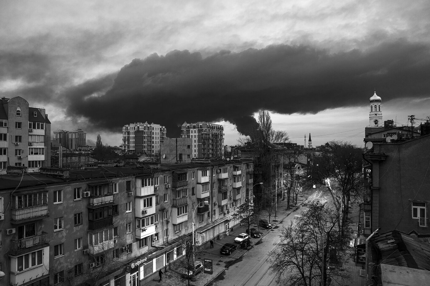 Dark cloud of smoke over a black and white city.